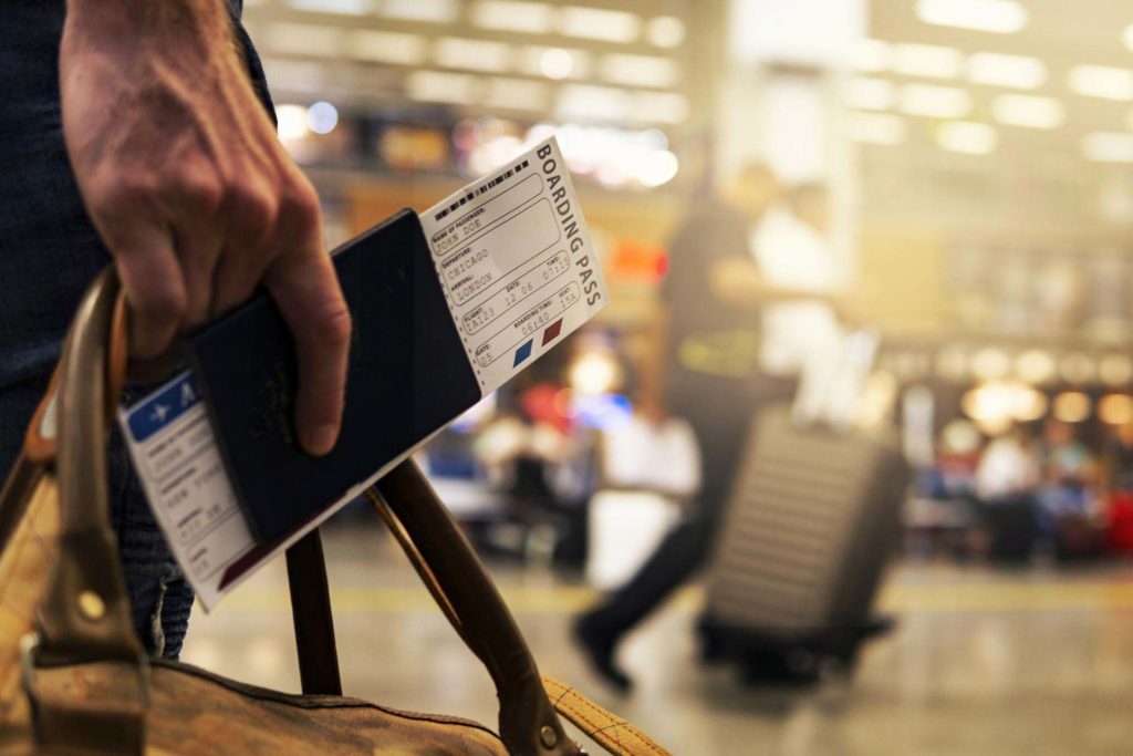 Hand mit Boardingticket am Flughafen